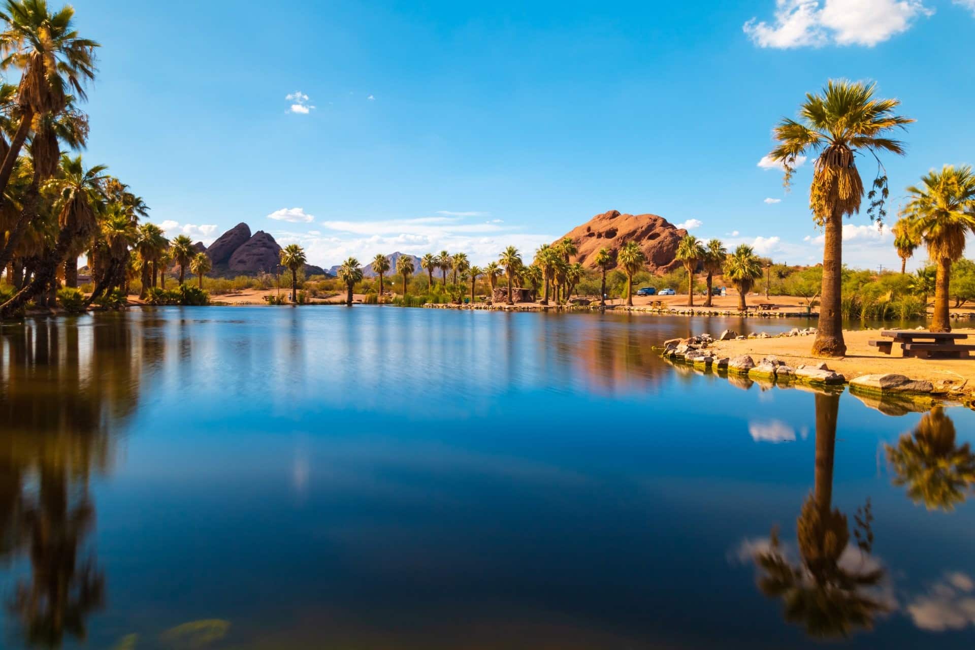 Papago Park in Phoenix with body of water in the foreground and mountains in the background